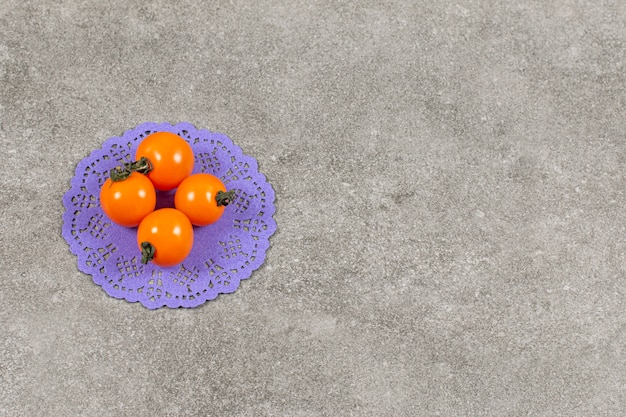 Organic yellow tomatoes on grey.