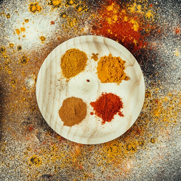 Oriental spices on round wooden plate