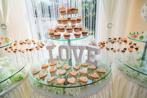 Original cupcakes stand before lettering LOVE on the tired glass