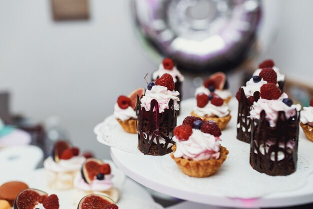 Original sweets with berries and chocolates served on white plat