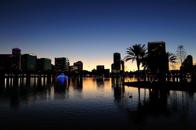 Orlando downtown skyline panorama silhouette over Lake Eola at dusk with urban skyscrapers.