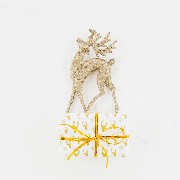 Ornament deer near gift box in wrap