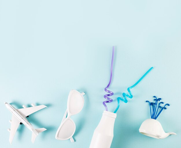 Ornamental sunglasses near toy plane with whale and bottle