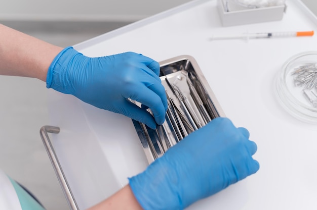 Orthodontist with latex gloves handling dental equipment