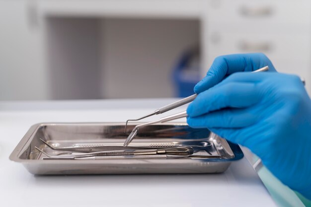 Orthodontist with latex gloves handling dental equipment