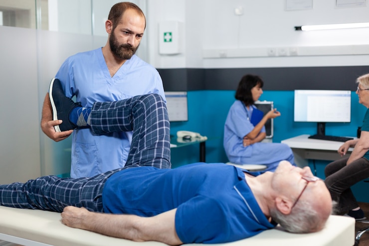 Free Photo orthopedic specialist assisting old patient with leg joint injury