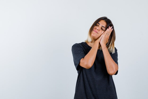 Ortrait of lady leaning on palms as pillow in black t-shirt and looking peaceful front view