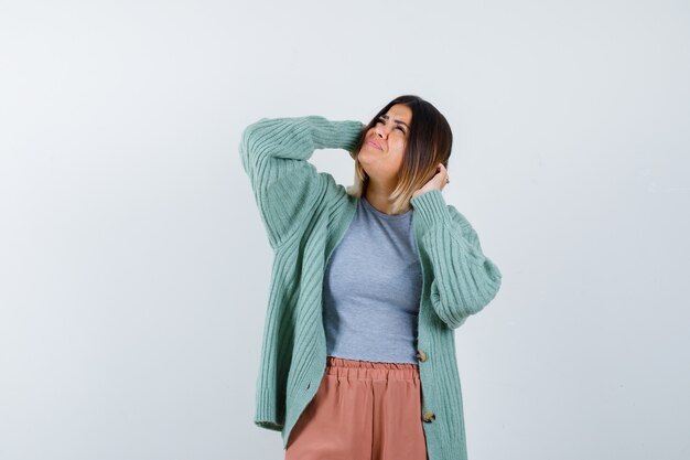 Ortrait of woman keeping hands on head in casual clothes and looking puzzled front view