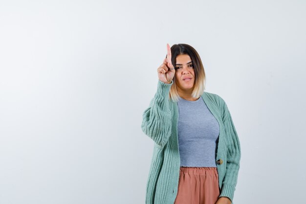 Ortrait of woman showing hold on a minute gesture in casual clothes and looking confident front view