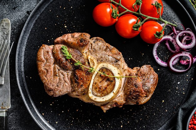 Premium Photo Osso buco meat with tomatoes on a plate Premium Photo Osso buco meat with tomatoes on a plate