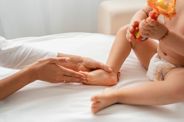 女の赤ちゃんの足を治療するオステオパシスト