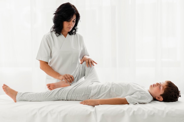 Osteopathist treating a kid by massaging him at the hospital