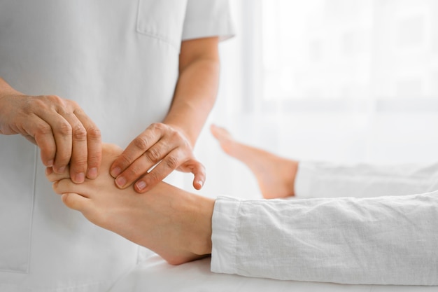 Free photo osteopathist treating a patient on his feet