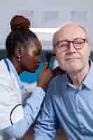 Free photo otologist of african ethnicity consulting elder patient