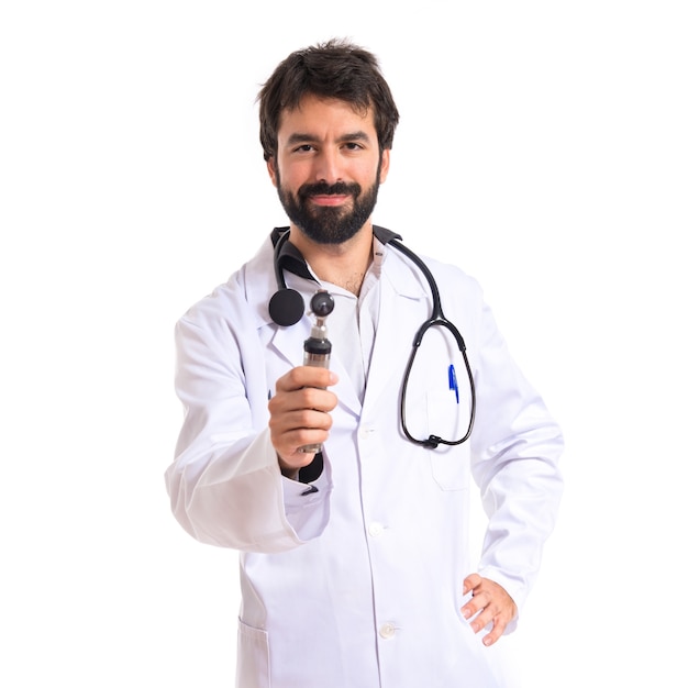 Otorhinolaryngologist with his otoscope over white background