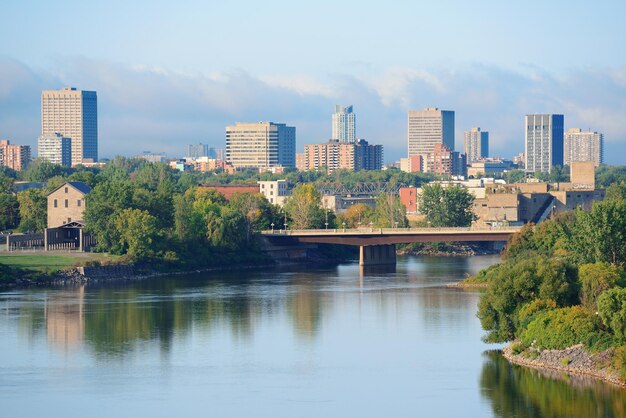 Ottawa cityscape in the day over river with historical architecture.