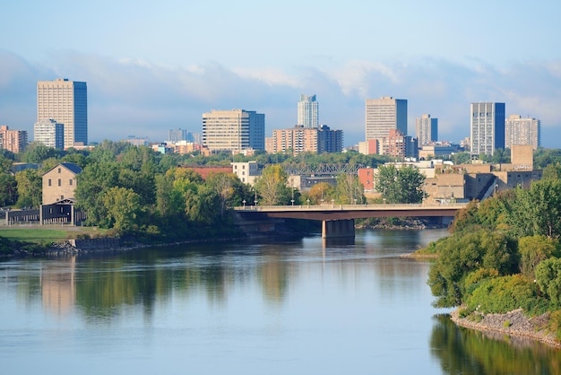 歴史的建造物のある川の向こうの日中のオタワの街並み。