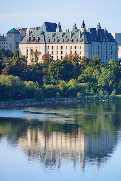 Ottawa cityscape in the day over river with historical architecture.