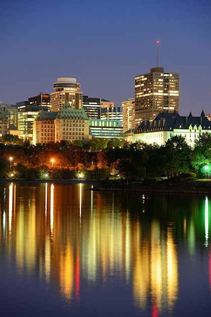 Ottawa at night over river with historical architecture.