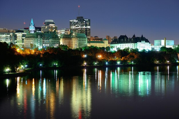 Ottawa at night over river with historical architecture.