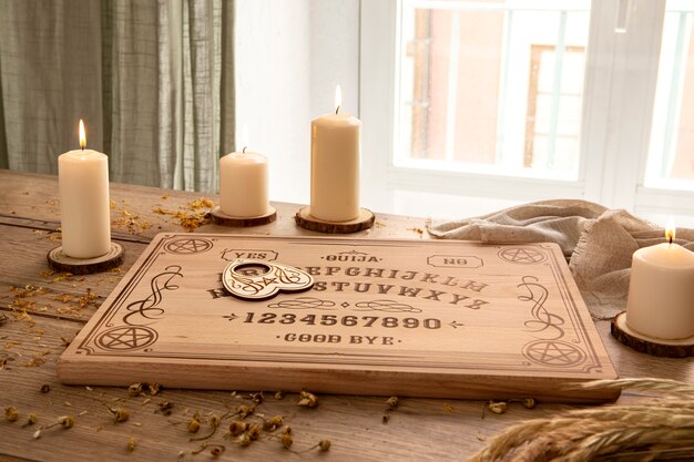 Ouija board and candles arrangement high angle