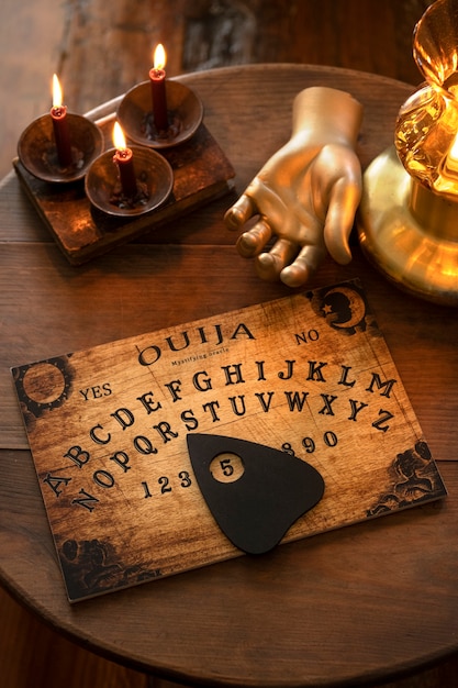 Ouija board and golden hand high angle