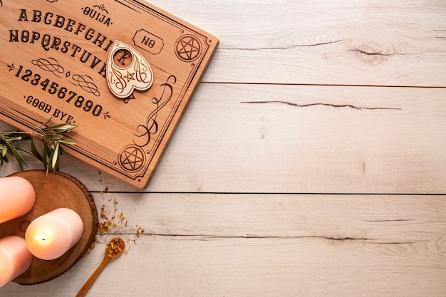 Ouija board on wooden table flat lay