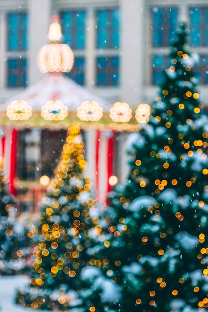 屋外のクリスマス ツリーに照らされた花輪の焦点が合っていないショット