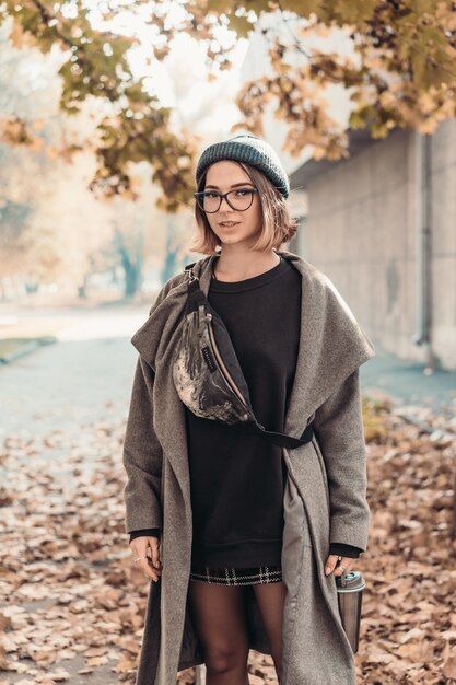 Outdoor autumn portrait of young woman, walking in street of European city.