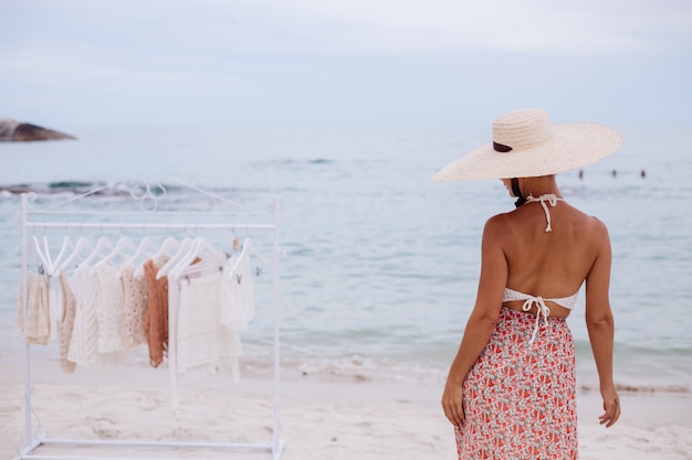Foto gratuita negozio all'aperto sulla spiaggia per la scelta di vestiti lavorati a maglia donna cosa comprare da appendiabiti concetto di abbigliamento lavorato a maglia estivo