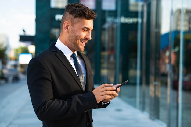 Outdoor businessman standing to a building