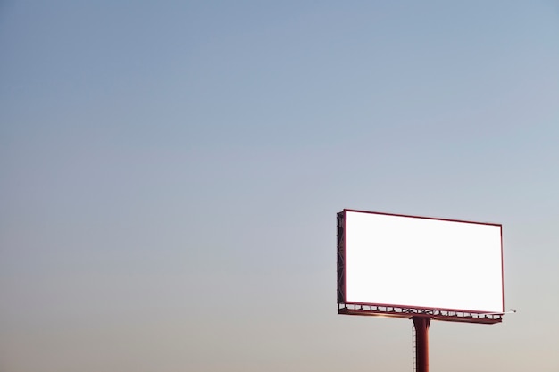 An outdoor empty advertising billboard against blue sky