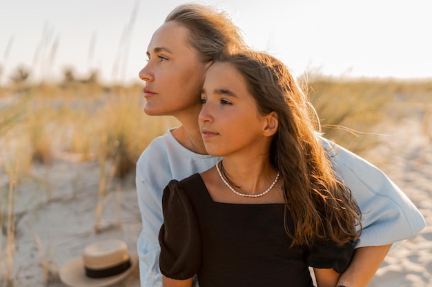 Outdoor fashion photo of beautiful family Mother and doughter posing on the beach