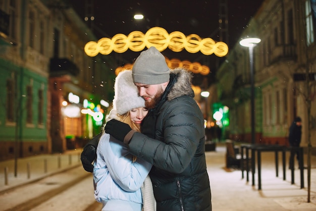 Outdoor night portrait of young couple posing in street