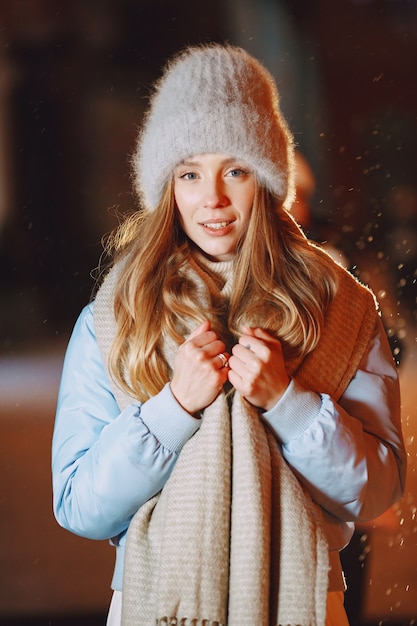 Outdoor night portrait of young woman posing in street