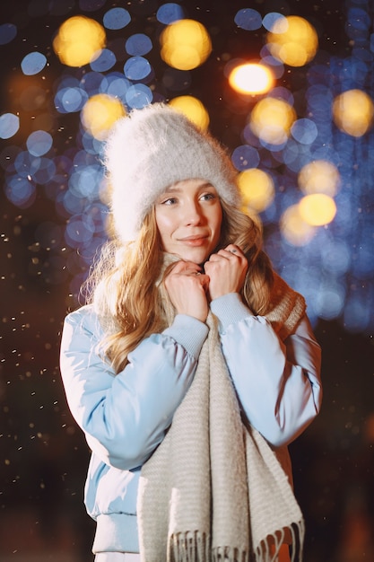 Outdoor night portrait of young woman posing in street