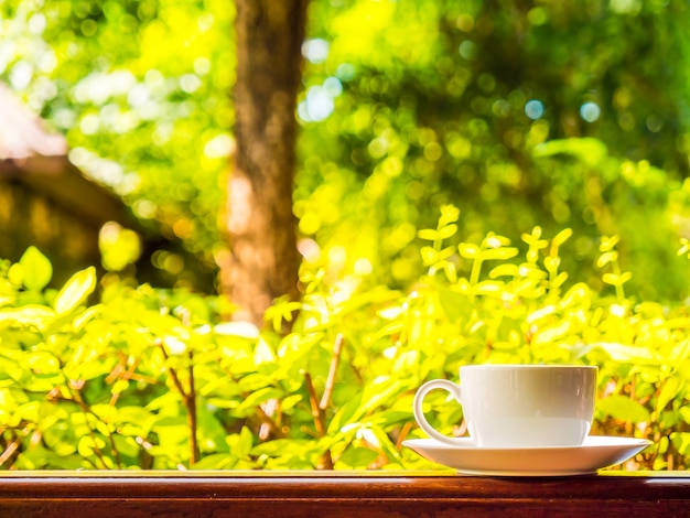 Foto gratuita patio esterno con splendida vista sulla natura e tazza di caffè bianco