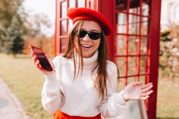 Outdoor photo of exited emotional long-haired female model having fun in weekend in Europe