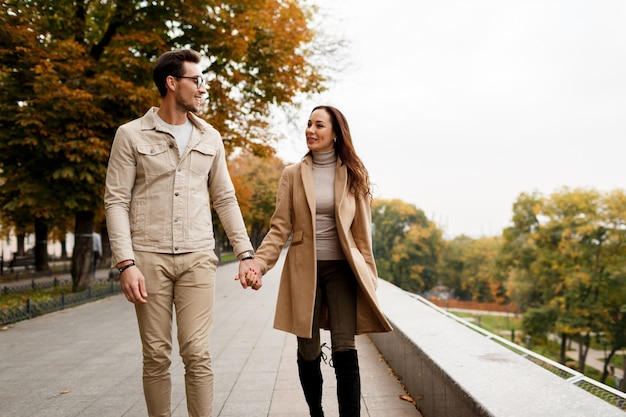 デートを楽しんでいる彼氏と幸せな若い女の屋外写真。寒い季節。