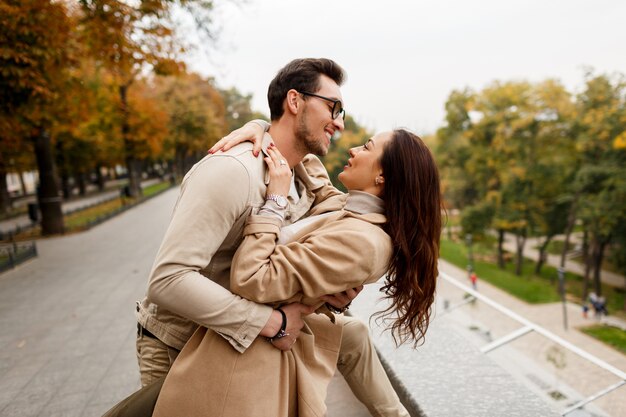 デートを楽しんでいる彼氏と幸せな若い女の屋外写真。寒い季節。