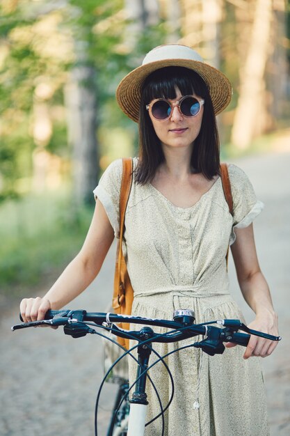 Внешний портрет привлекательного молодого брюнет в шляпе на велосипеде.