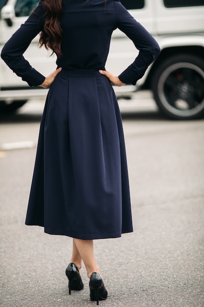 Free photo outdoor portrait of beautiful fashionable lady standing against the car on the background. female fashion. city lifestyle