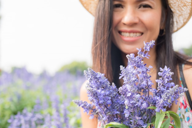 outdoor portrait of a beautiful middle aged asia woman. attractive girl in a field with flowers