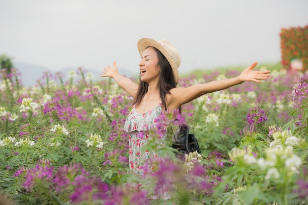 美しい中年のアジア女性の屋外のポートレート。花を持つフィールドで魅力的な女の子