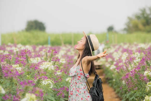 美しい中年のアジア女性の屋外のポートレート。花を持つフィールドで魅力的な女の子