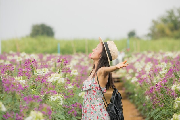 美しい中年のアジア女性の屋外のポートレート。花を持つフィールドで魅力的な女の子