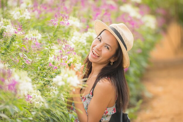 outdoor portrait of a beautiful middle aged asia woman. attractive girl in a field with flowers