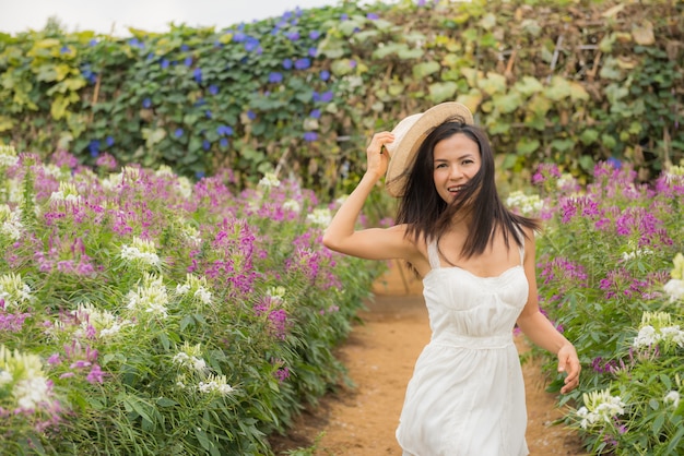 outdoor portrait of a beautiful middle aged asia woman. attractive girl in a field with flowers