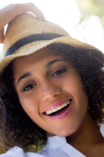 Outdoor Portrait of beautiful young woman posing with hat