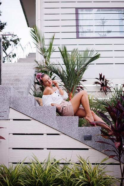 Outdoor portrait of stylish european woman on pink fashion suit outside villa